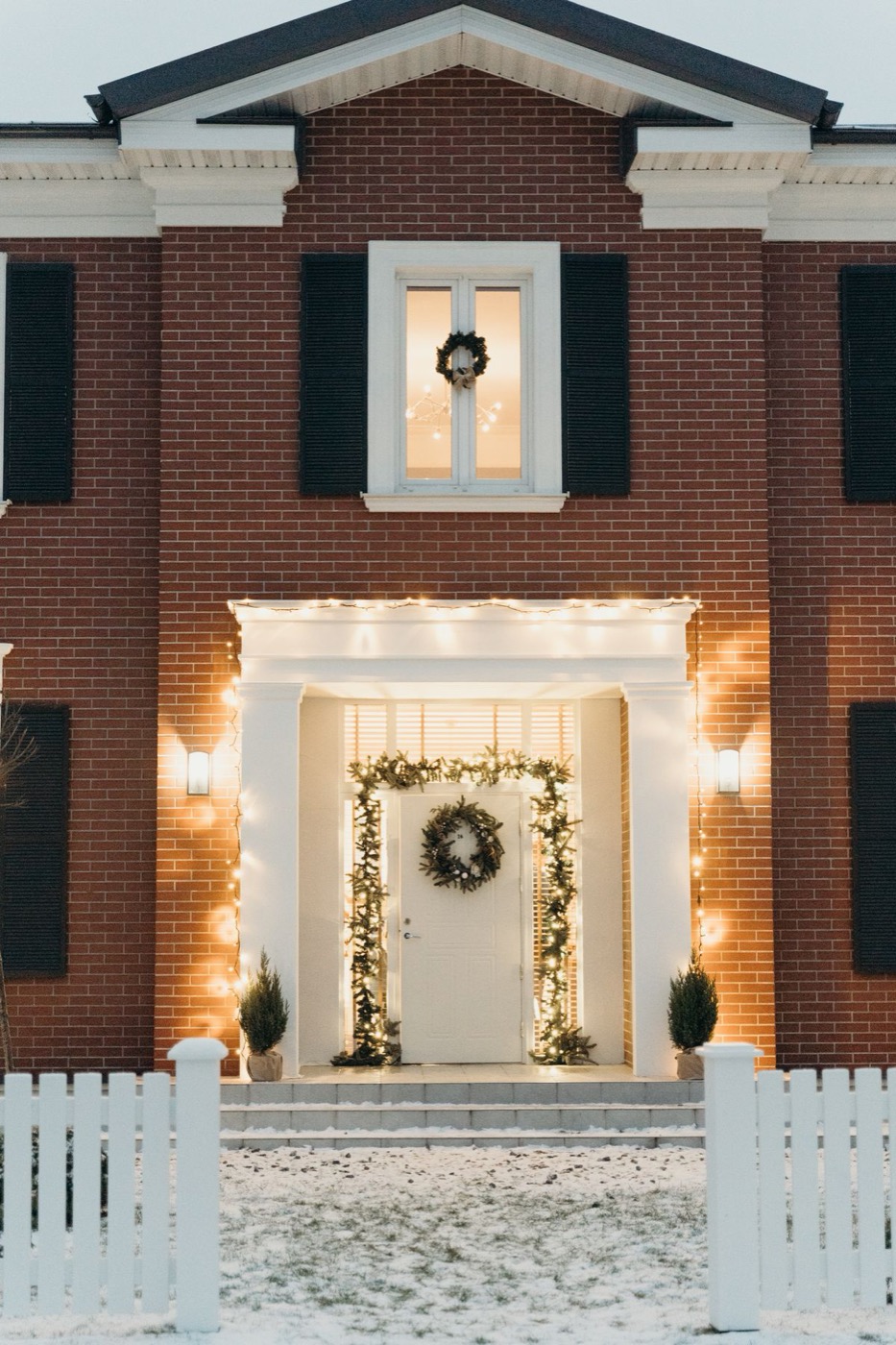 House entrance decorated with Christmas lights and wreaths