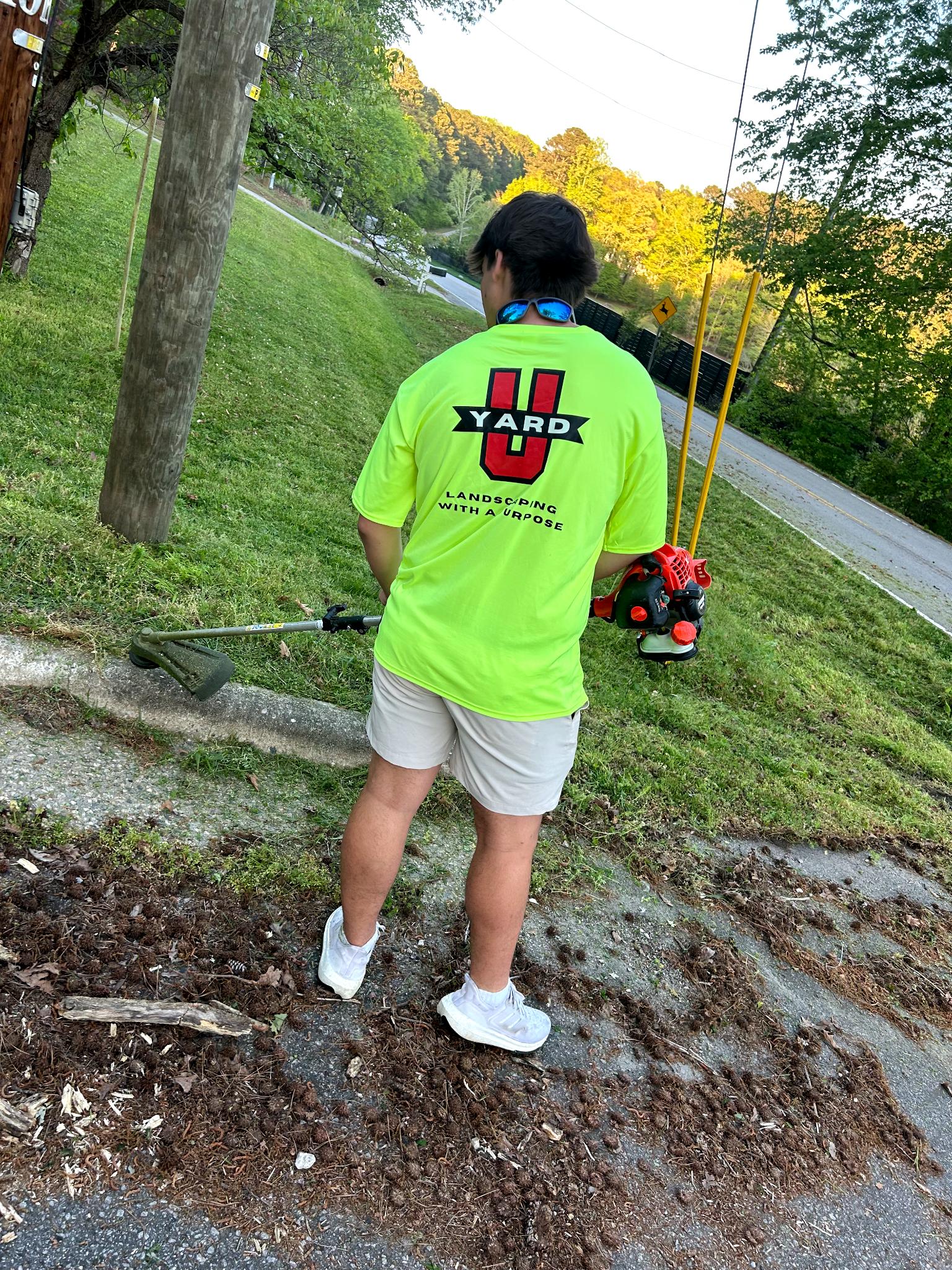 YardU employee trimming back grass