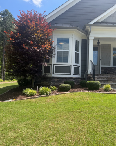 Front of House with mulch spread between bushes